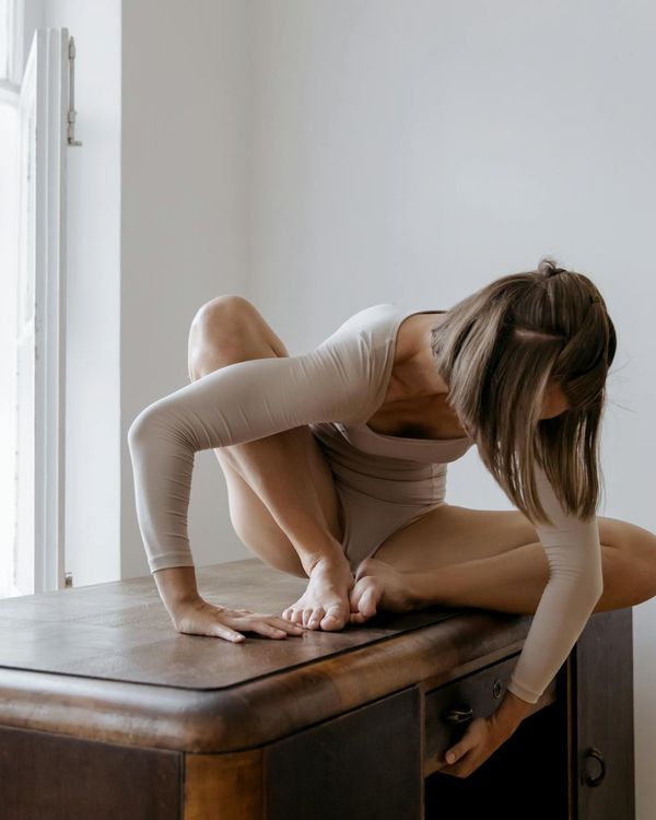 Woman in a graceful yoga pose in a bright and calm studio.